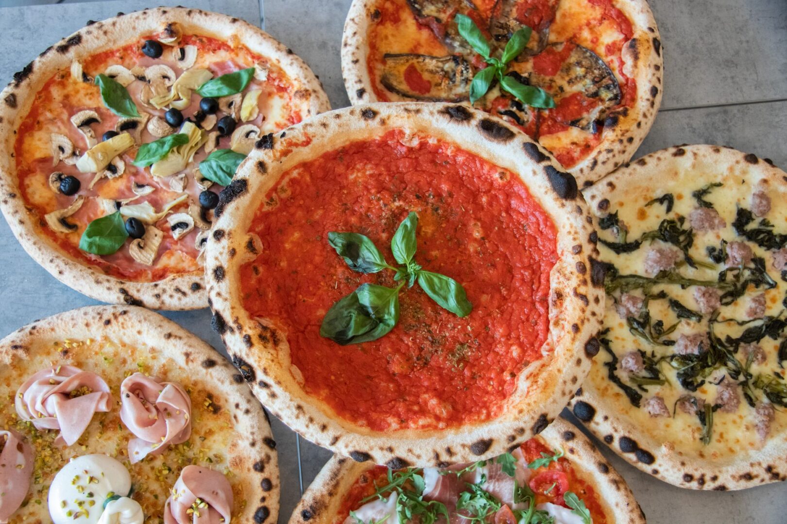 5 Pizzas italianas encima de la mesa